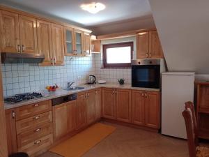 弗济内Apartman Centar Fužine的厨房配有木制橱柜和白色冰箱。