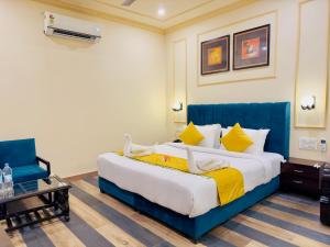 乌代浦Udai Valley Resort- Top Rated Resort in Udaipur with mountain view的一间卧室配有一张大床和蓝色床头板