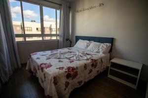 本图贡萨尔维斯WineAP - Pensando em Vinhos的一间卧室配有一张带鲜花毯子的床和窗户。