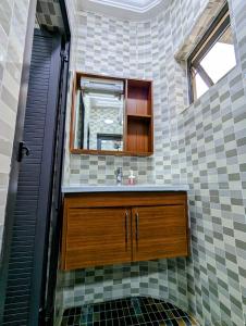科托努Les Ombrelles Appart'Hotel的一间带水槽和镜子的浴室
