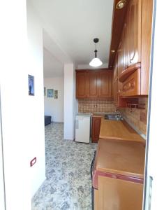培拉特RINA'S Apartment的厨房配有木制橱柜和白色冰箱。