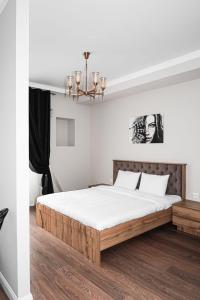 阿拉木图Deluxe Park Z hotel的一间卧室配有一张带白色床单和吊灯的床。