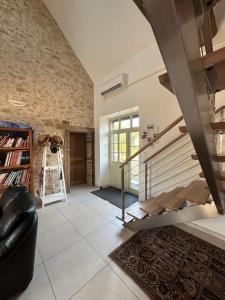 Lussac-les-ÉglisesCharmante maison au coeur du Limousin - Comme à la maison的一间带楼梯和沙发的客厅