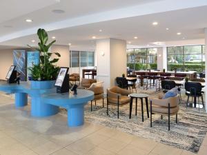 悉尼Mercure Sydney Manly Warringah的一个带桌椅的大堂和一间餐厅