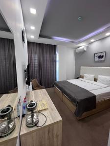 巴库Noor hotel的一间卧室配有一张大床和一张桌子及一张床