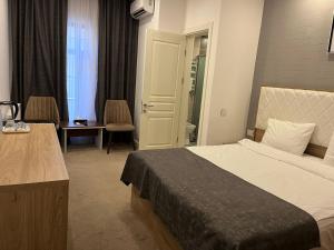 巴库Noor hotel的酒店客房带一张床、一张桌子和椅子