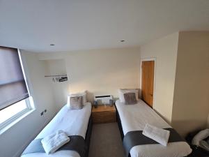 伊普斯威奇Modern 2 bedrooms apartment in Town Centre 10的客房设有两张床和窗户。