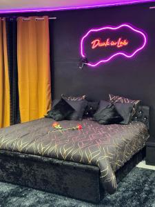 佩皮尼昂LoveRoom by Sunnyroom的墙上有 ⁇ 虹灯标志的床