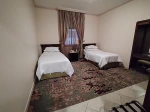 吉达فندق روتانة الحمراء的酒店客房带两张床和地毯