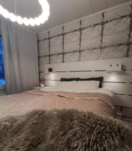 罗瓦涅米Rovaniemi - quality detached house with sauna nearby services的一间卧室配有一张大床和毛绒毯子
