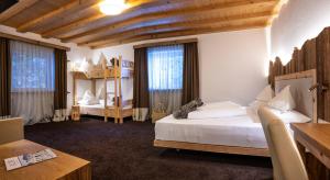 阿尔卑斯休斯山施慕恩酒店的一间卧室配有两张床、一张桌子和一张书桌
