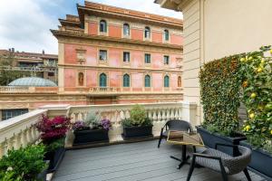 罗马罗马哈尔定制套房酒店的一个带植物和椅子的阳台,以及一座建筑