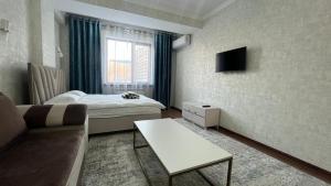 比什凯克Apartament Manasa的小房间设有床和沙发
