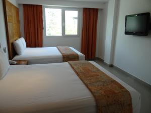 坎昆盖比套房酒店的酒店客房设有两张床和电视。