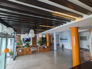 科托努Les Ombrelles Appart'Hotel的大堂设有橙色柱子和带灯的天花板
