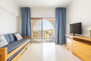 珀彻斯Casa Azul 3 - Senhora da Rocha, Algarve的带沙发和电视的客厅以及阳台。