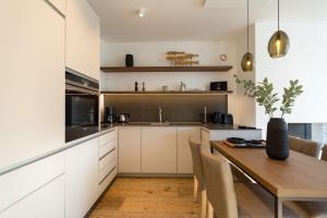 赛巴特班森Beachhouse Bansin App 06的厨房配有白色橱柜和木桌