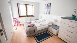 克雷尼察Apartamenty Sun & Snow Zielona的一间卧室配有一张床和一张红色椅子