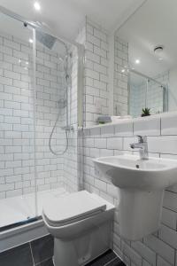 曼彻斯特Morden 2 Bed Apartment - Manchester Old Trafford的白色的浴室设有卫生间和水槽。