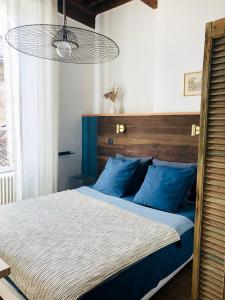 于泽斯La bohème place aux herbes的一间卧室配有一张带蓝色枕头的大床