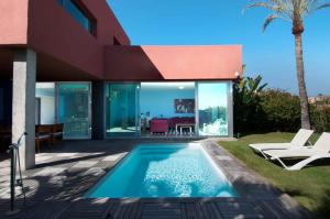 萨洛夫雷Salobre Villas的一座带游泳池和房子的别墅