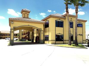 布朗斯维尔博卡奇卡套房酒店 的前面有棕榈树的建筑