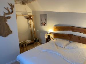 奥尔贝多梅因德罗勒餐厅酒店的卧室配有一张床,墙上挂着鹿头