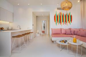 弗尔卡Cocoοns Luxury Suites & Villas的厨房以及带粉红色沙发的起居室。