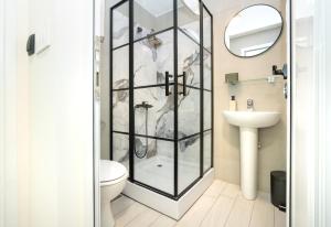 波德戈里察7 Hills Suites的带淋浴、卫生间和盥洗盆的浴室
