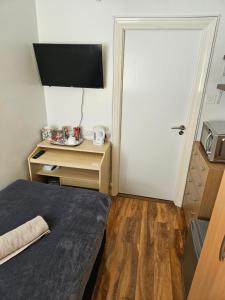 NortholtComfortable single room in Family home, Heathrow airport的客房设有一张床、一张书桌和电视