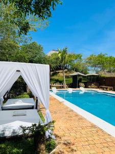 维兰库卢什Mangal Beach Lodge的游泳池旁设有帐篷和椅子