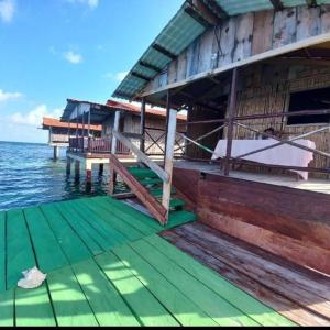 NusatupoCabañas sobre el mar en San Blas Narasgandub.的水边的房子,有绿色的甲板