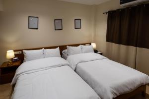 开罗Marron Serviced Studios and Rooms的配有白色床单的酒店客房内的两张床