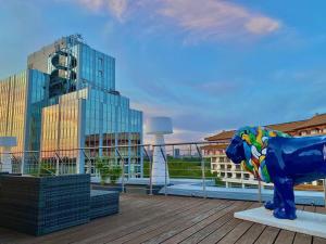 美因河畔法兰克福帕拉贡公寓式酒店的坐在甲板上的一个蓝色牛雕像