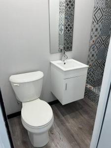 阿雷西博Huellas的浴室配有白色卫生间和盥洗盆。