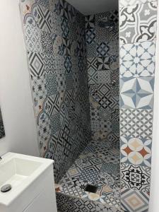 阿雷西博Huellas的浴室设有水槽和瓷砖,配有淋浴。