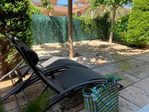 马力诺港Private Garden in Novamar 5的坐在院子里的黑色草坪椅
