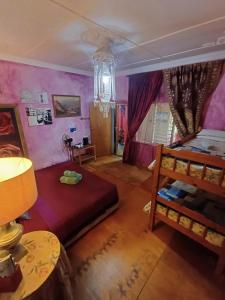 普利登堡湾Holt Hill的卧室设有紫色墙壁、一张床和一张桌子