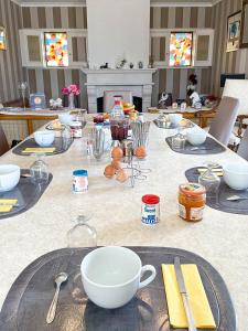 康卡勒曼萨尔迪尔住宿加早餐酒店的桌子上放有盘子和碗