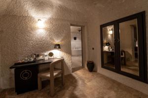 格雷梅Artemis Cave Suites & Spa- Adults Only的浴室设有梳妆台、镜子和椅子