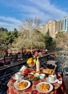 巴库Nizami Central Street Hotel的阳台上摆放着食物盘的桌子