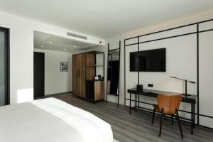 突尼斯Radisson Hotel Tunis, City Center的一间卧室配有一张床、一张书桌和一台电视