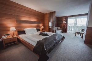 塞尔瓦迪加尔代纳山谷大陆酒店的酒店客房,设有一张带木墙的大床