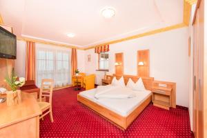 萨尔巴赫Hotel Astrid的配有一张床和一张书桌的酒店客房