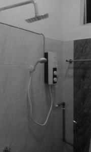 哥打巴鲁Airport Kota Bharu Homestay & Riverview Inn的带淋浴的浴室,浴室的软管连接着墙壁