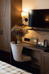 瓦尔卡斯兰卡纳德皮利卡酒店的客房设有一张桌子、一把椅子和一台电视