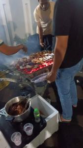 哥打巴鲁Airport Kota Bharu Homestay & Riverview Inn的站在炉子旁的人,上面有食物