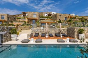 帕诺尔莫斯米科诺斯Panormos Bay Suites Luxury Resort的一座别墅,在一座建筑前设有一个游泳池