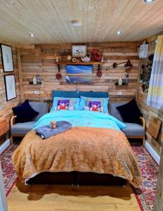 SwafieldLILAC COTTAGE cabin的一间卧室设有一张床和木墙