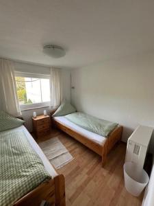 希尔兴巴赫Ferienhaus Konze的一间卧室设有两张床和窗户。